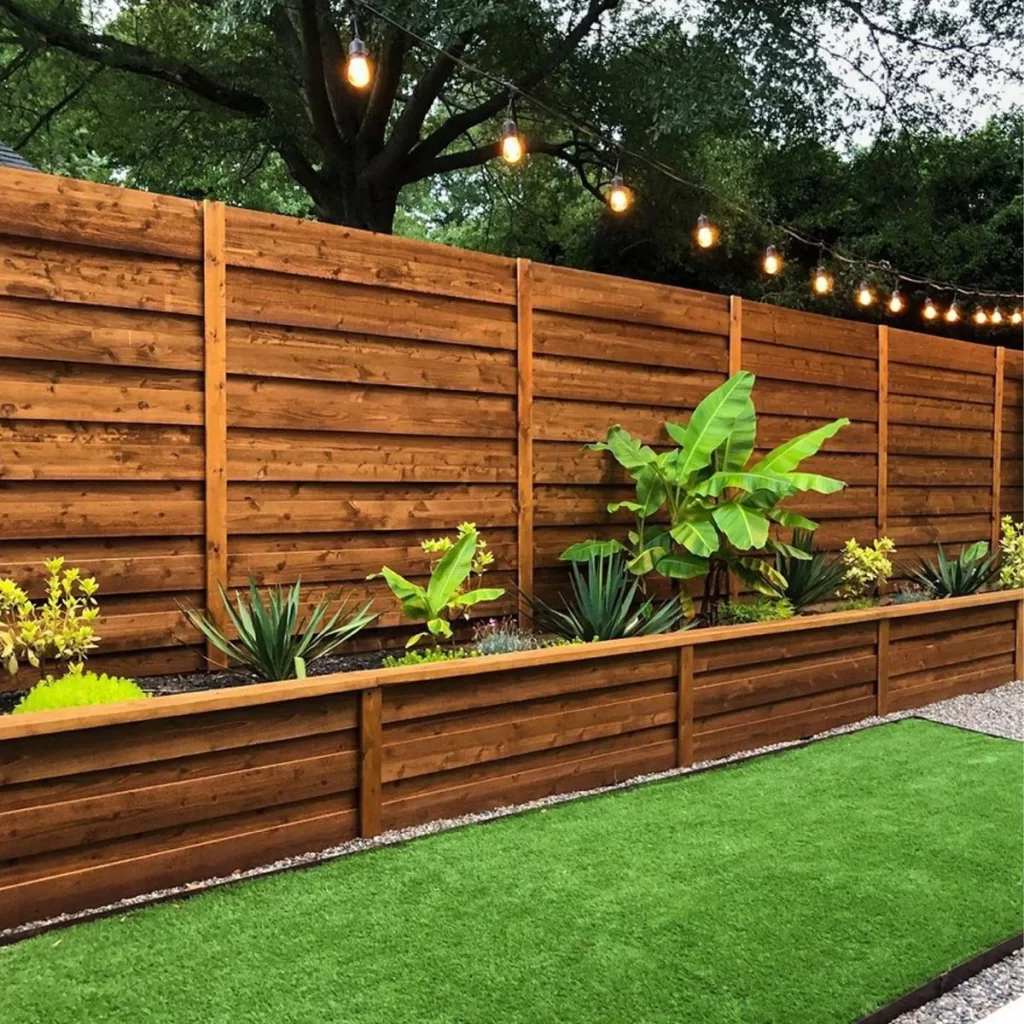 Horizontal wood fence with a matching raised planter and artificial turf